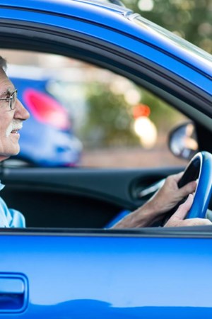 Older male driver in blue car.jpg